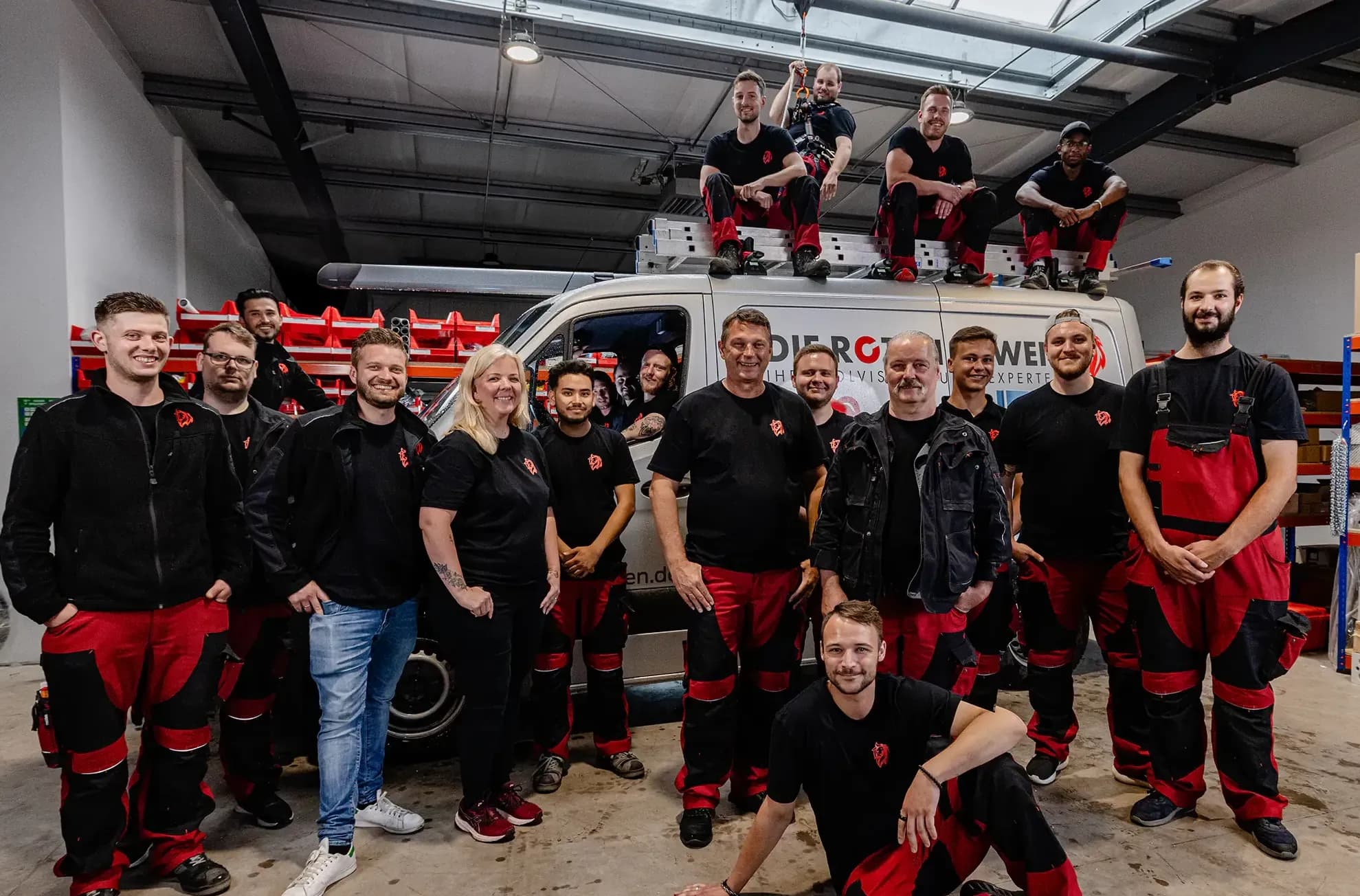 Die Roten Löwen Teamfoto - Gruppenbild Hochformat vor dem Firmenfahrzeug