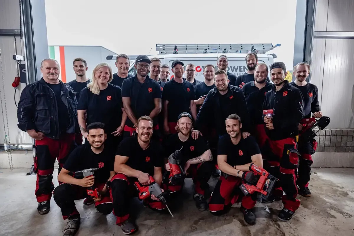 Team der Roten Löwen Braunschweig mit Werkzeug vor Firmenfahrzeug, Heizung und Installation