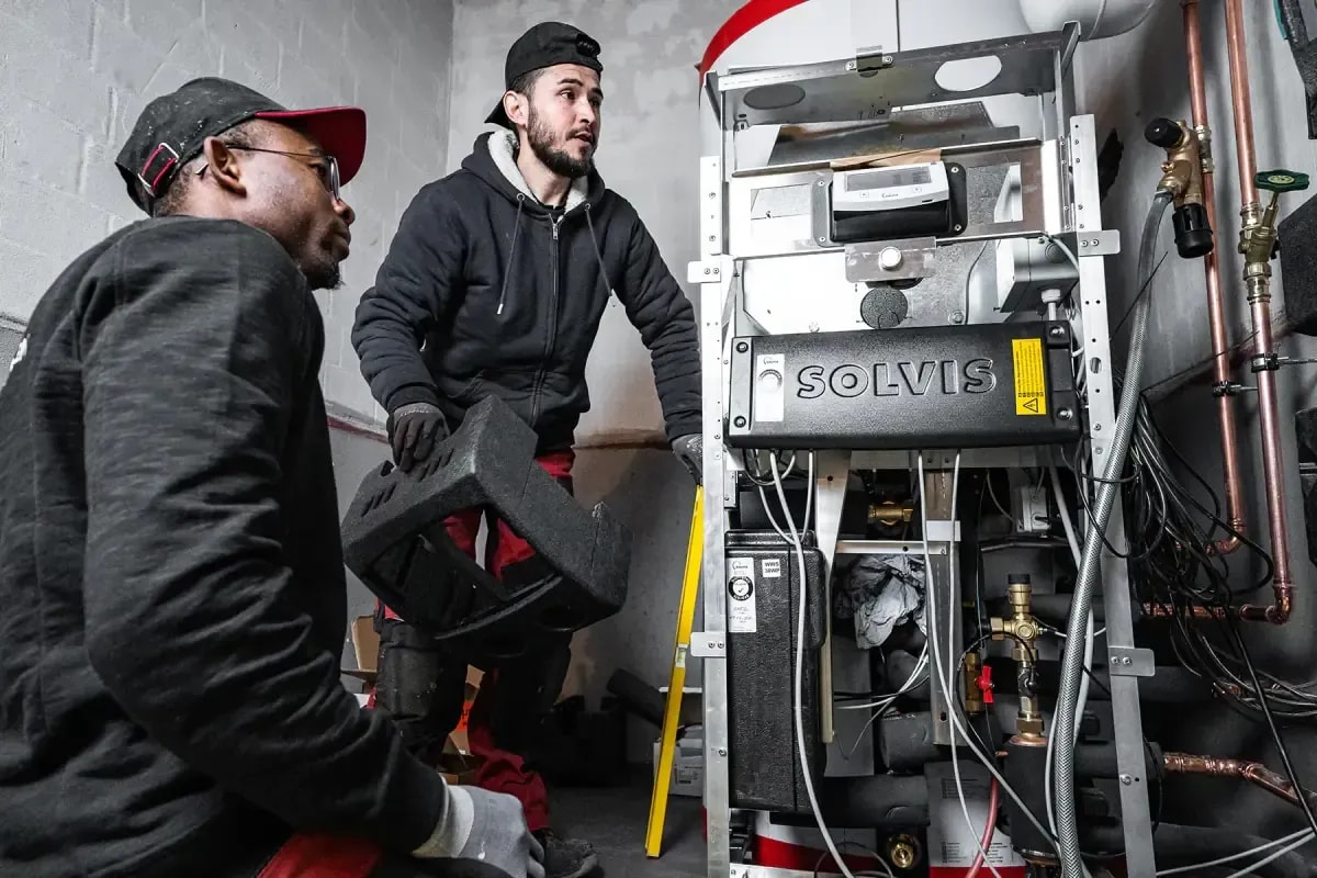 Zwei Monteure installieren eine Solvis Heizungsanlage im Heizungskeller