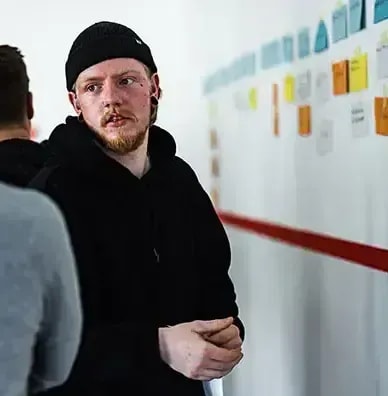 Zwei Mitarbeiter besprechen an einer Planungswand ein Heizungsprojekt im Team