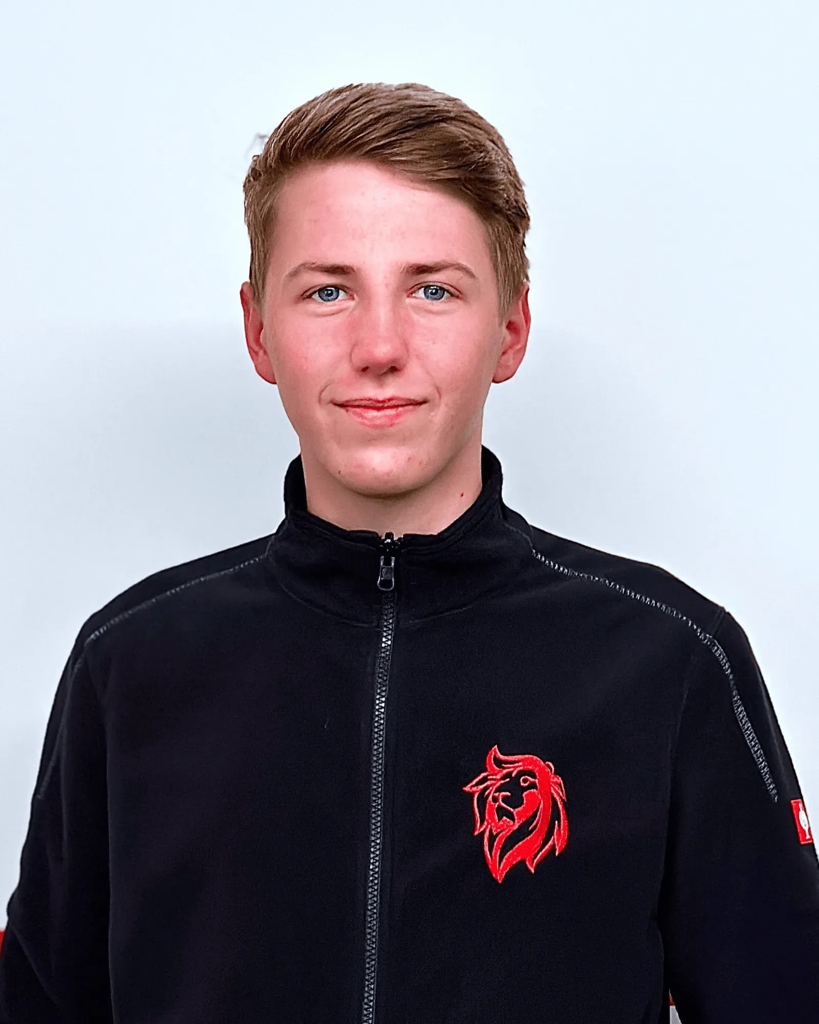 Junger Mitarbeiter der Roten Löwen Braunschweig in schwarzer Firmenjacke mit rotem Löwen-Logo